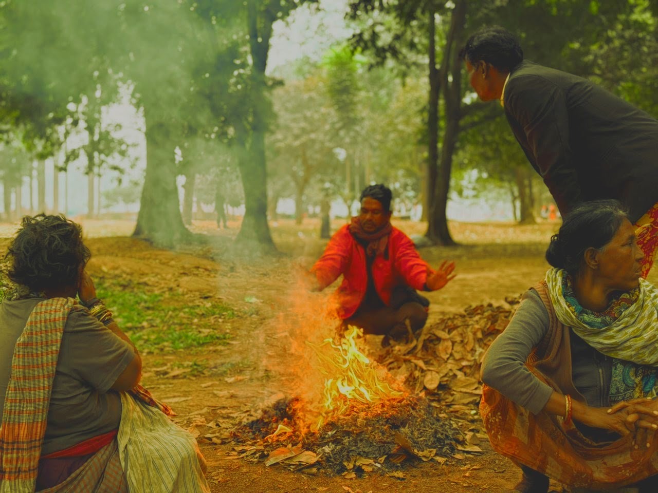 Three People enjoying the warmness of fire during winter
